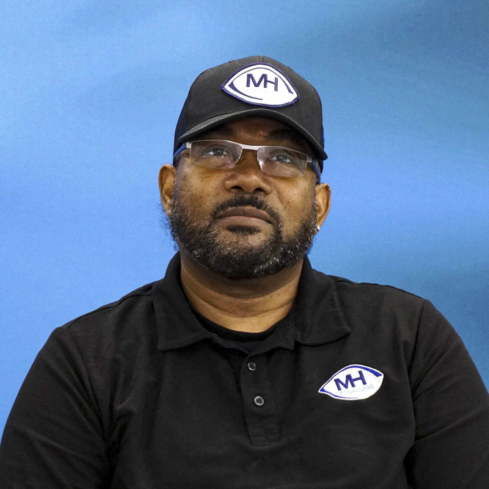 A man wearing glasses and a hat.