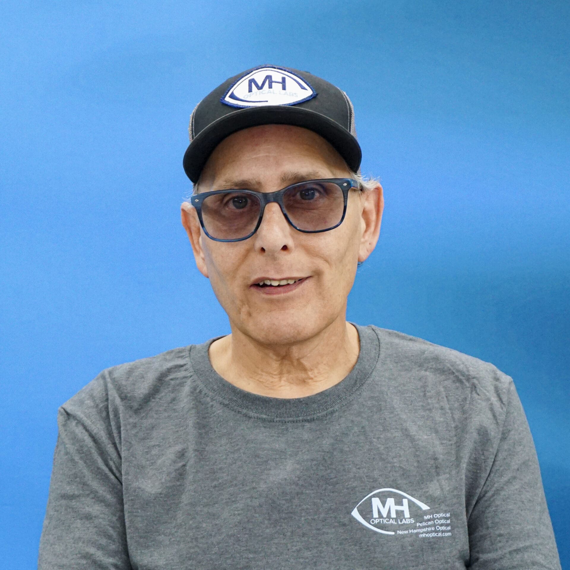 A man wearing glasses and a hat.