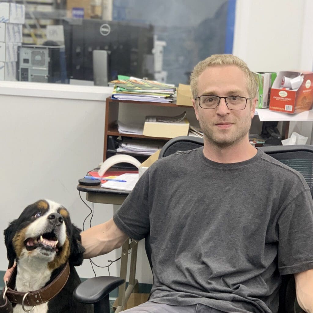 A man sitting in front of a dog.