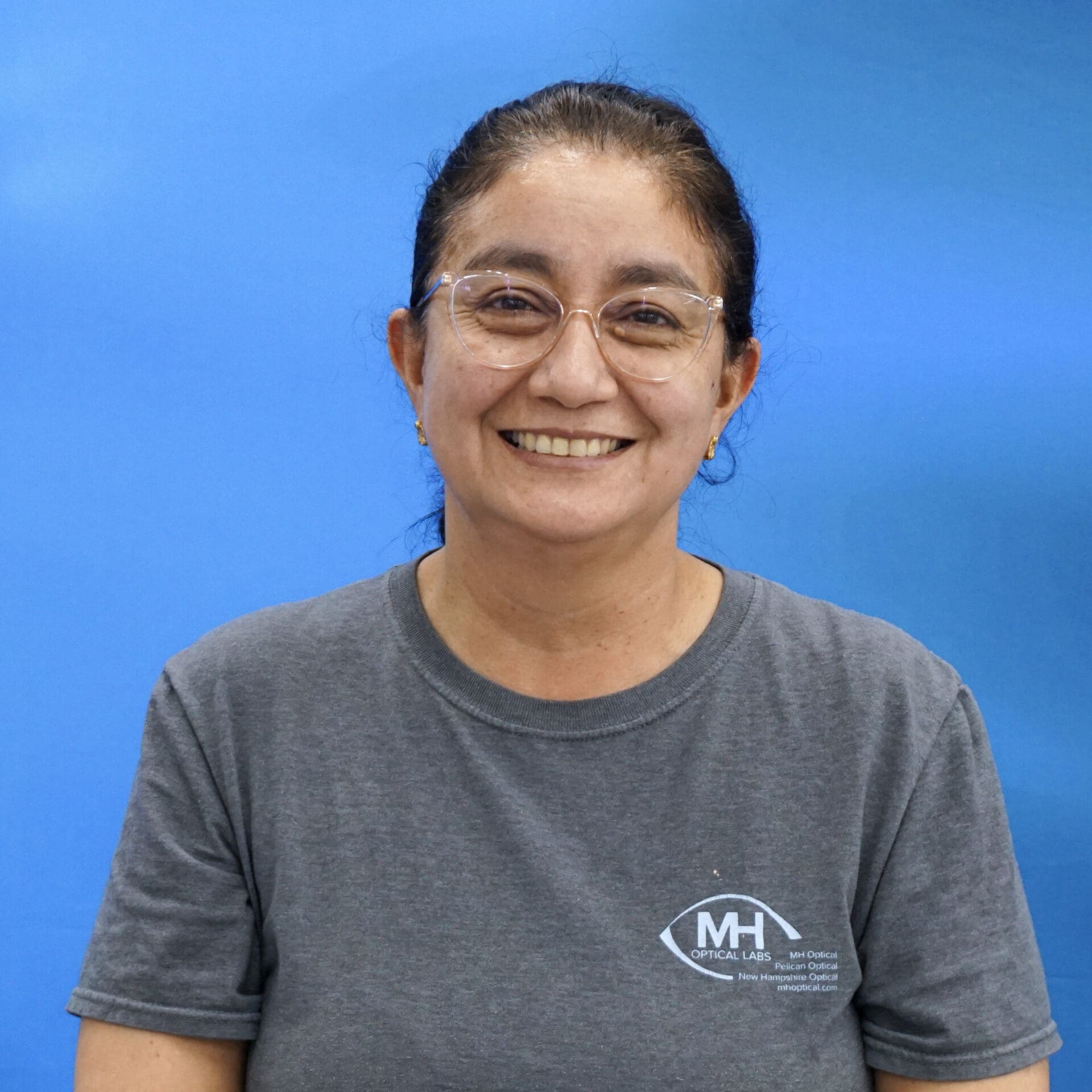 A woman wearing glasses and smiling for the camera.