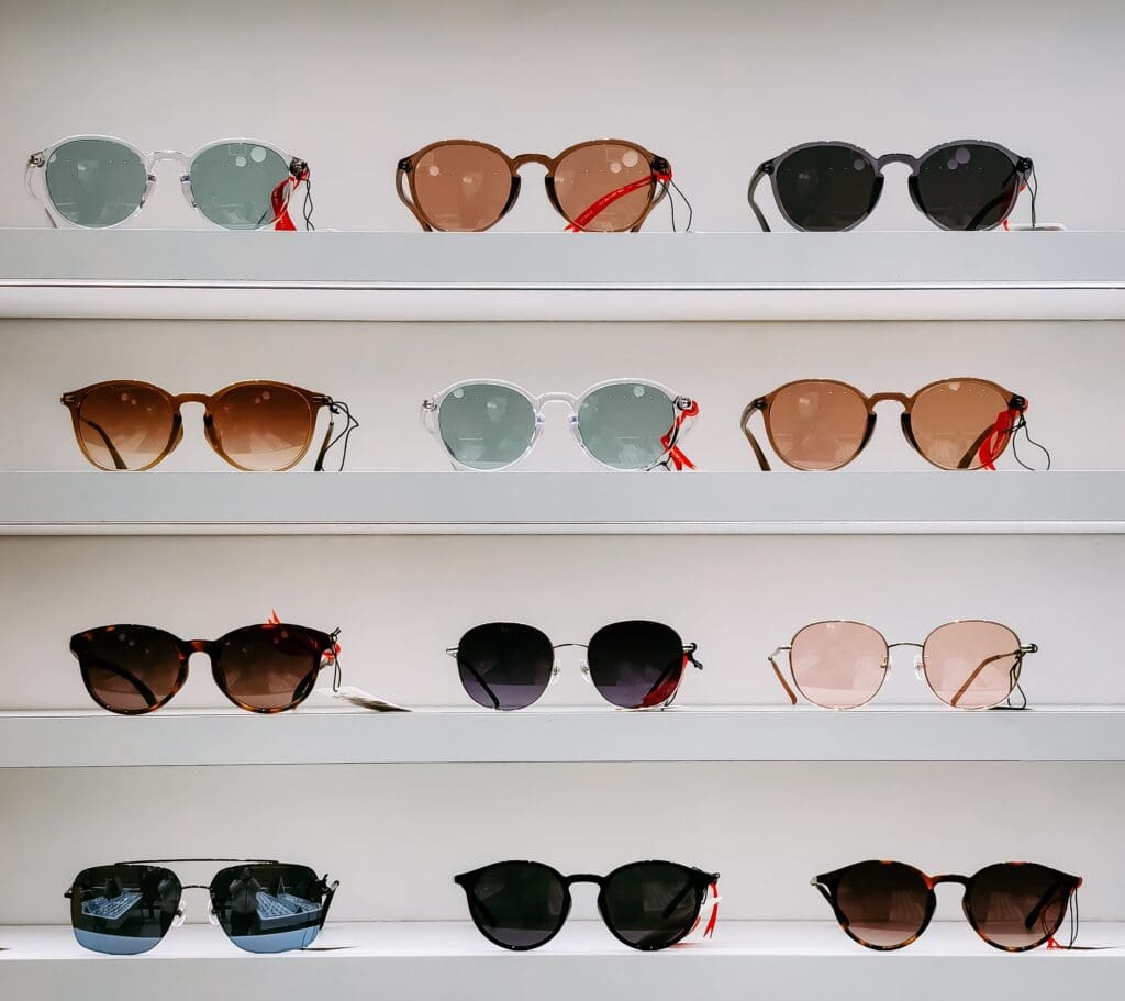 A row of sunglasses on display in front of a wall.