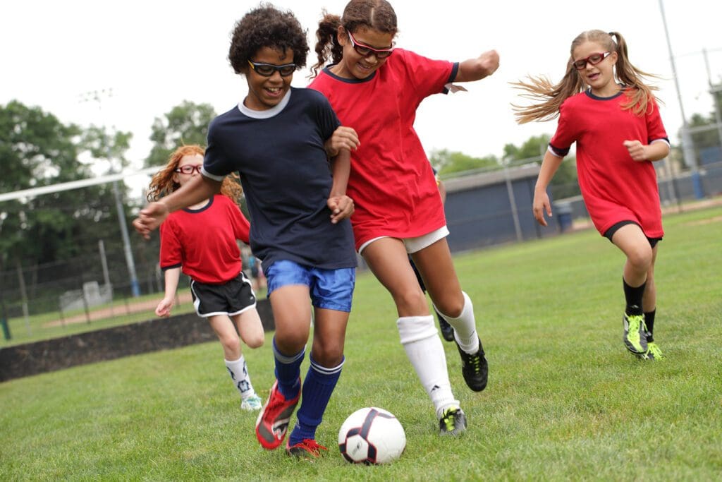 A group of young girls playing soccer on the field.