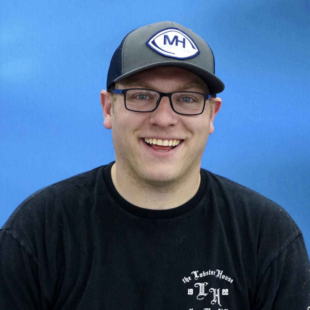 A man wearing glasses and a hat.