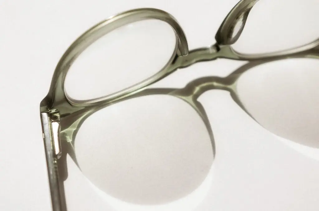 A pair of glasses with a pair of scissors in the middle.
