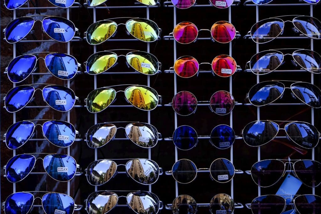 A display of many pairs of sunglasses in different colors.