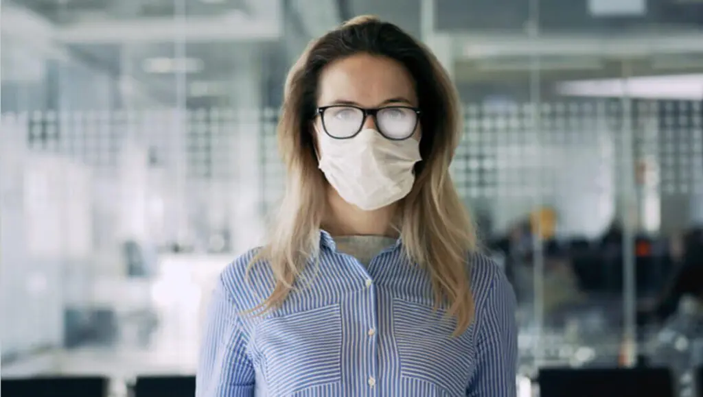 A woman wearing glasses and a face mask.